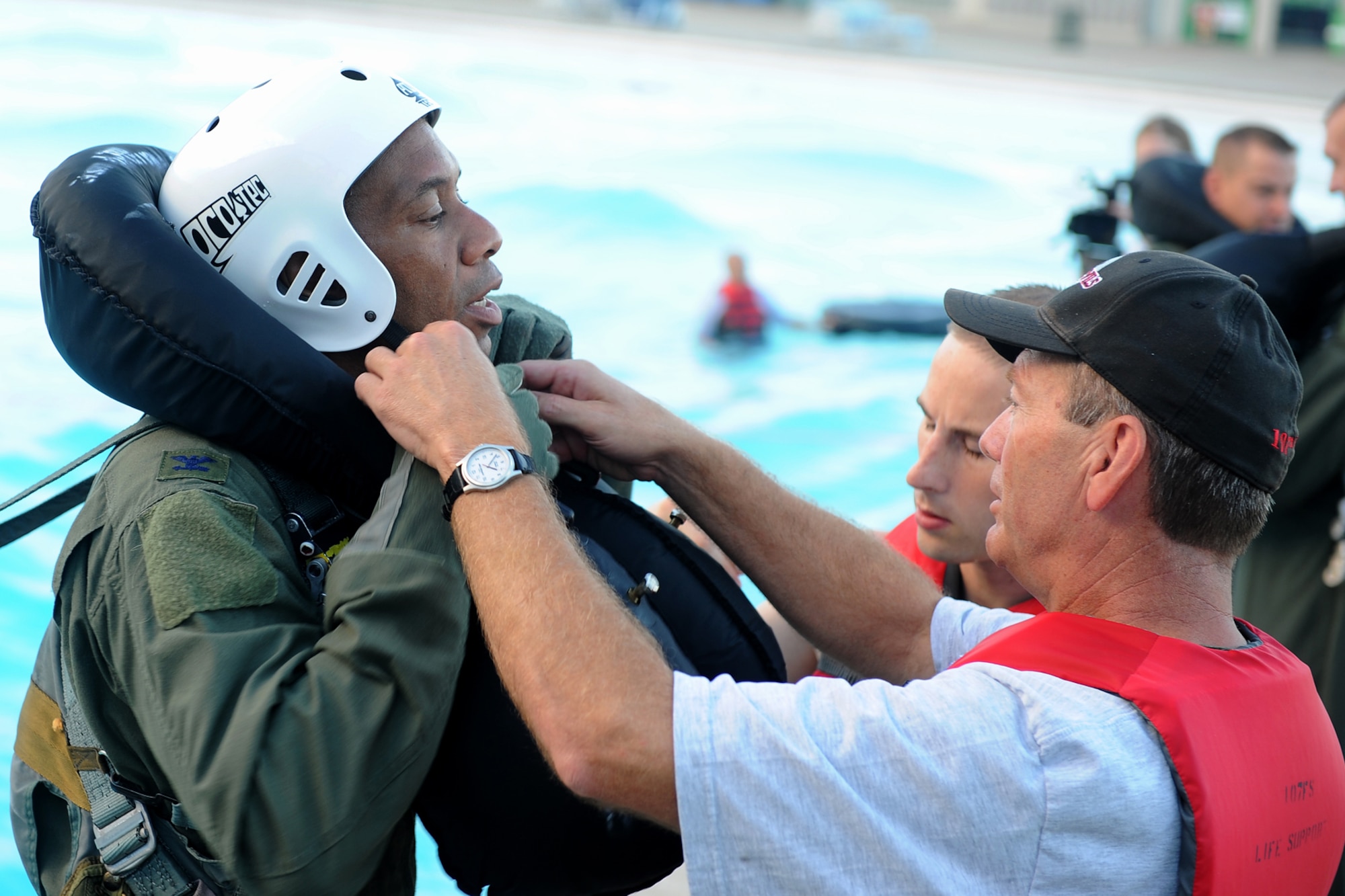 Col. Leonard Isabelle, 127th Operations Group commander, is assisted by members of the 107th Fighter Squadron’s air crew flight equipment team prior to beginning his water survival refresher training, Aug. 15, 2010. During the training, pilots from Selfridge Air National Guard Base were pulled into the wave pool at Red Oaks Water Park in Madison Heights, Mich., to simulate the pull of a parachute. The pilots then had to extricate themselves from the parachute harness. The pilots are required to undergo the water survival training once every three years. (U.S. Air Force photo by TSgt. Dan Heaton) (RELEASED)