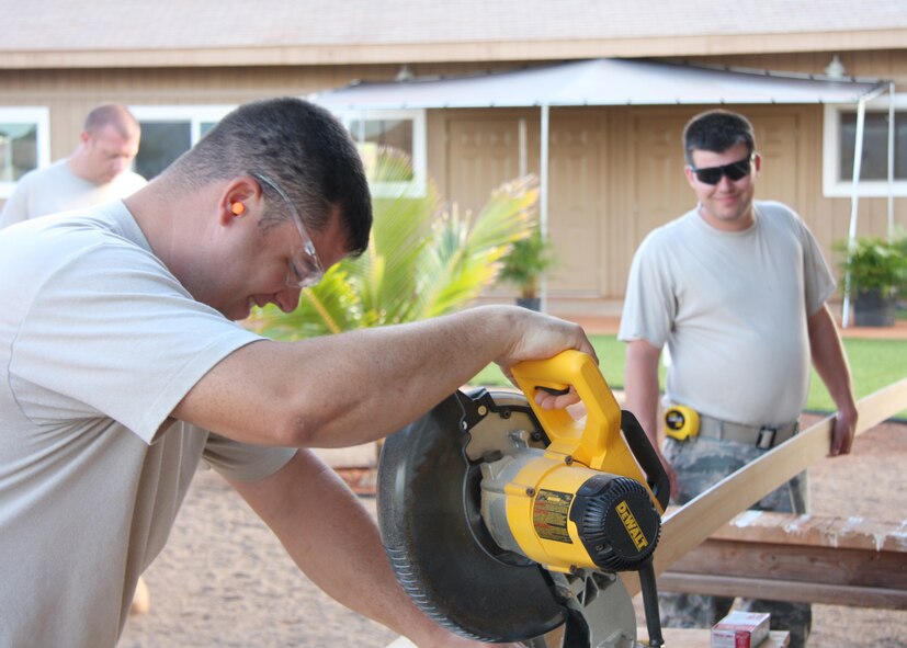 Master Sgt. Jason Woodworth and Staff Sgt. Brian O'Shea from the 131st Civil Engineering Squadron, cut base board trim for the cabins June 15, Wahiawa, Hawaii.  (Photo by Tech Sgt. Virginia Todd)