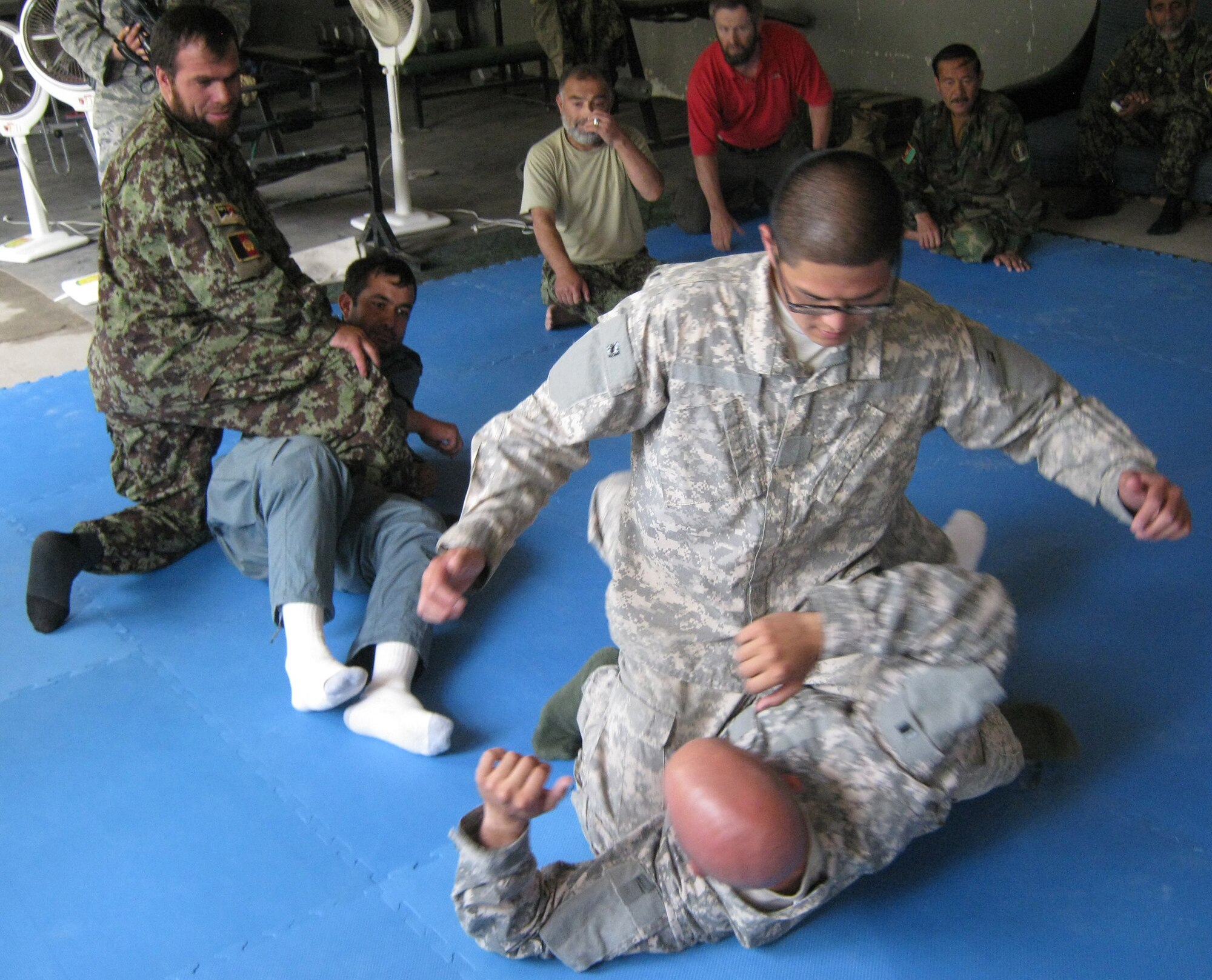 U.S. Army Staff Sgt. Daniel Cornell (bottom), a Philadelphia native, and U.S. Army Sgt. Richard Yoon, a Fort Lee, N.J., native, both members of the Task Force Wolverine Embedded Training Team with Provincial Reconstruction Team Panjshir, demonstrate combatives techniques Aug. 14. Cornell and Yoon taught U.S. Army Combatives techniques to Afghan National Police trainers so they can teach the skill to other ANP officers in each of the seven districts in the Panjshir Province, Afghanistan. (Photo by U.S. Air Force 2nd Lt. Jason Smith, PRT Panjshir Public Affairs)