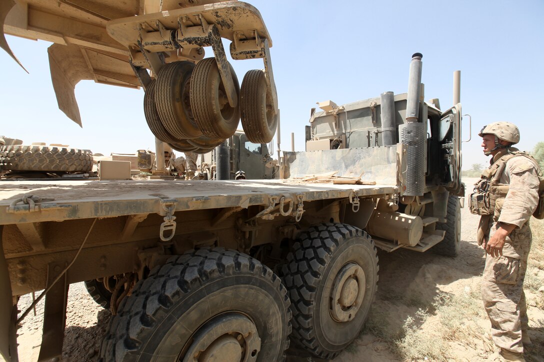 Marines with Combat Logistics Battalion 5, 1st Marine Logistics Group (Forward), load a mine roller onto the back of a Medium Tactical Vehicle Replacement during a combat logistics patrol in Helmand province, Afghanistan, Aug. 15. If a vehicle or mine roller ever becomes stuck or damaged while on a combat logistics patrol, a wrecker team assists in recovering the vehicle.