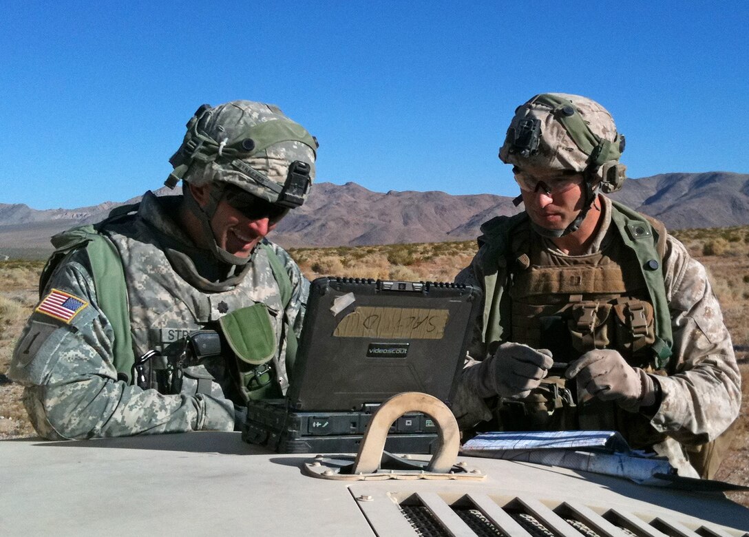Marine Capt. Joshua D. Rogerson (right), the team leader for Supporting Arms Liaison Team D, 2nd Air-Naval Gunfire Liaison Company, II Marine Expeditionary Force Headquarters Group, plans with, Army Lt. Col. Alan Streeter, the battalion commander for 2nd Battalion 2nd Infantry Regiment, 3rd Brigade Combat Team, 1st Infantry Division at the Army’s National Training Center aboard Fort Irwin, Calif., Aug. 15, 2010. During July and Aug., 2nd ANGLICO’s 2nd Brigade Platoon participated in training rotation 10-09 with 3rd BCT in order to conduct supporting arms planning, execution, liaison, and interoperability training with joint and coalition forces in preparation for an Operation Enduring Freedom deployment.