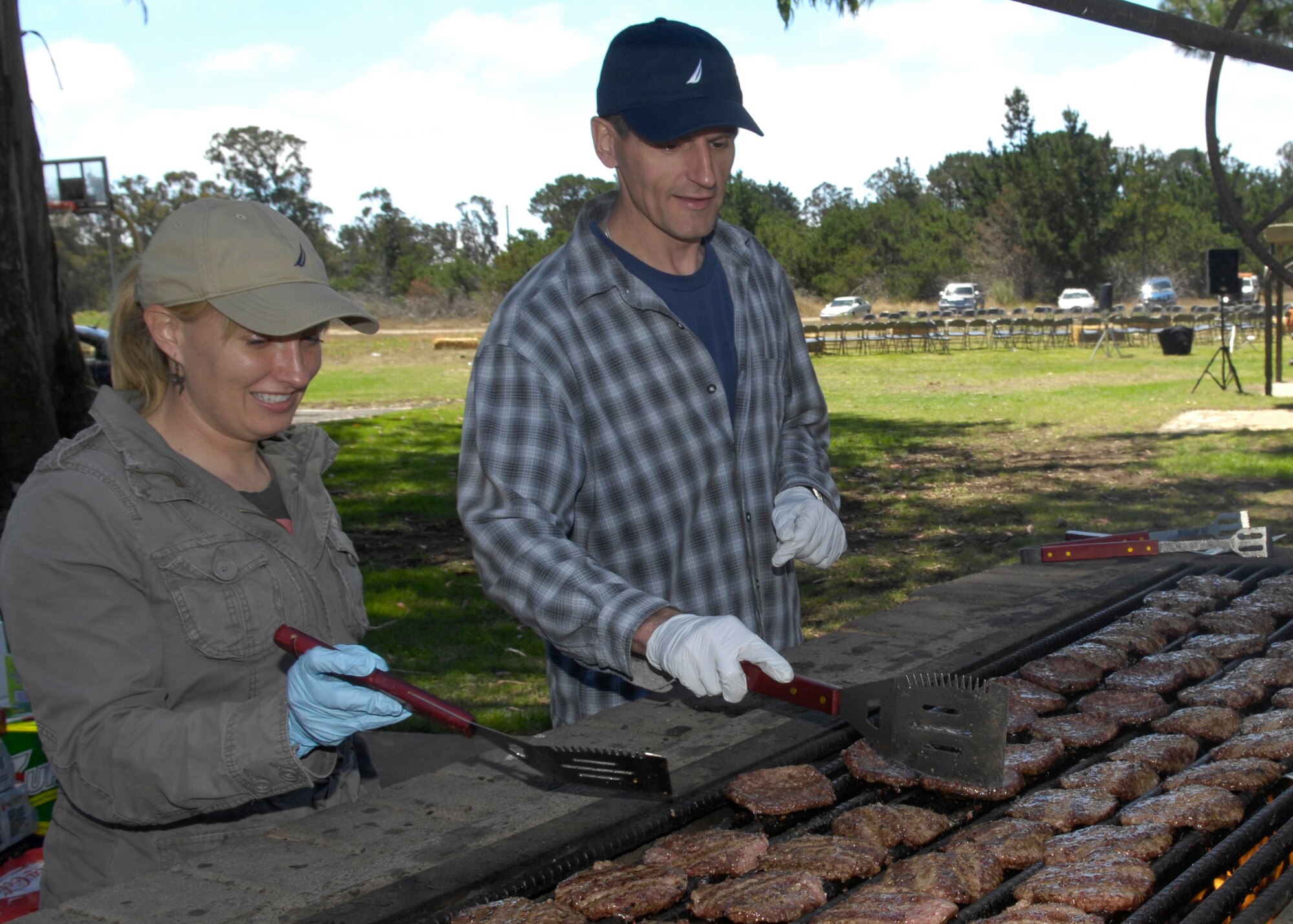 VANDENBERG AIR FORCE BASE, Calif. – Volunteers man the grill during the 381st Training Group’s Texas Blowout barbecue at Cocheo Park here, Aug. 13, 2010. The event featured a cow pie tossing contest, bake sale, games for children, car show and lots of food. (U.S. Air Force photo/Airman 1st Class Lael Huss)