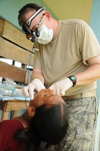 YAPUWAS, Honduras --  Lt. Col. Thomas Edmonson, a dentist with the Medical Element at Soto Cano Air Base, inspects a patients mouth before an extraction during the medical civic action program here Aug. 11. Colonel Edmonson, along with Honduran military and civilian dentists, conducted more than 100 extractions over the four-day MEDCAP. (U.S. Air Force photo/Tech. Sgt. Benjamin Rojek)