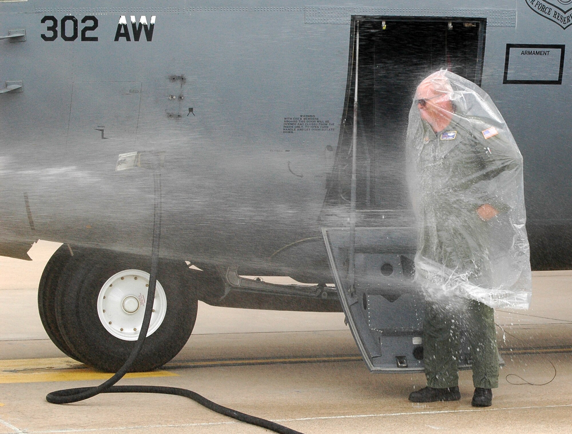 Col. Bob Chapman stands tall in the face of a congratulatory water spray while protecting himself with a plastic chemical bag Aug. 8 at Peterson Air Force Base, Colo. The colonel's spraying, a tradition conducted when a pilot has his or her final flight with the unit they're assigned to, culminated his flying career with the Air Force Reserve's 302nd Airlift Wing.  The flight capped off his military flying career with more than 5,200 hours of flight, including over combat zones. Colonel Chapman, who relinquished his position as the wing's vice commander during the August unit training assembly, has served in the Air Force since 1978 when he joined as an enlisted member. The colonel left Active Duty in 1992, becoming an Air Force Reserve member with the 302nd AW. The colonel is projected to retire in March 2011. (U.S. Air Force photo/Maj. Kallece Quinn)