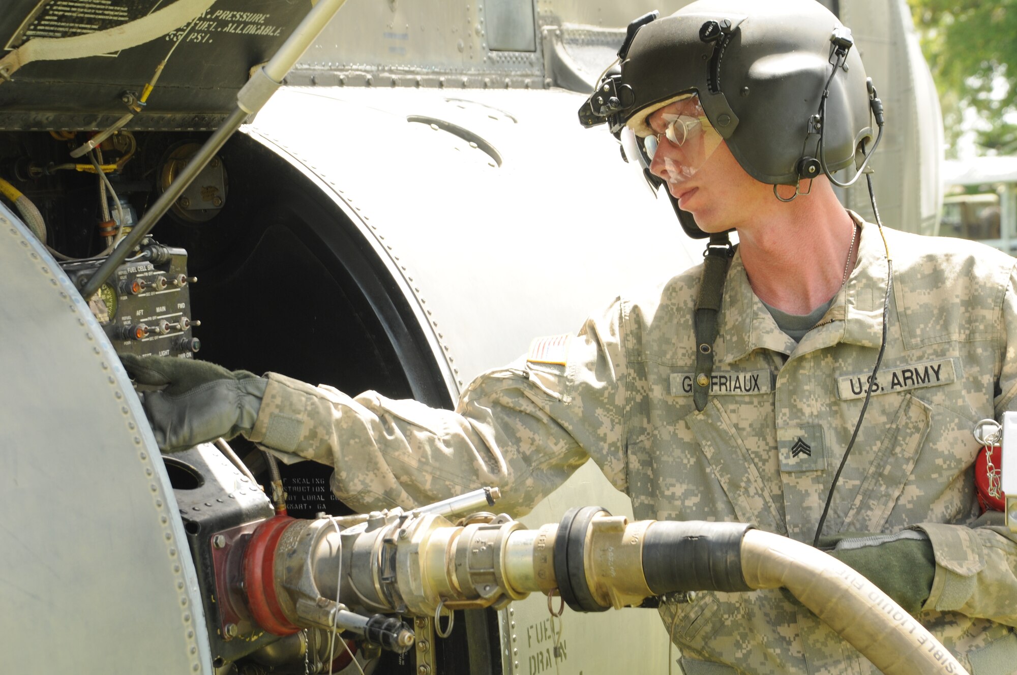 CATACAMAS, Honduras --  Sgt. Brian Godfriaux, a crew chief with the 1-228th Aviation Regiment at Soto Cano Air Base, checks on the progress of a refuel here Aug. 9. Many moving parts made the medical civic action program in La Moskitia province possible, including fuels technicians, pilots and crew chiefs, drivers and medical personnel. (U.S. Air Force photo/Tech. Sgt. Benjamin Rojek)