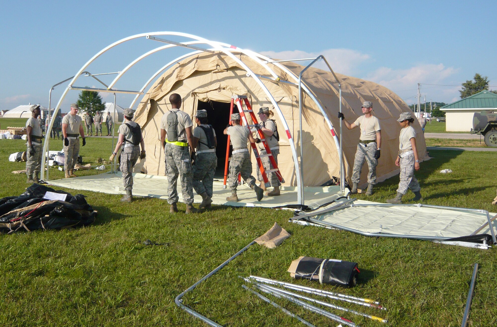 Medical professionals construct Alaskan shelters to set up expeditionary medical support during Operation Vibrant Response, a training exercise July 12 through 22, 2010, at Camp Atterbury, Ind. (U.S. Air Force photo/Maj. Sandra Keesee) 

