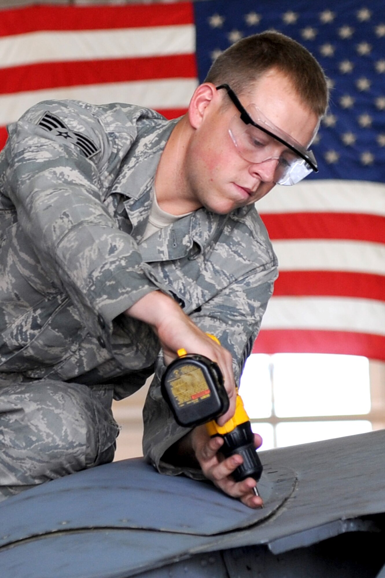 Staff Sgt. Michael Mahaney, 906th Air Refueling Squadron, reinstalls a beaver tail panel on a KC-135 Stratotanker at Scott AFB, July 20, 2010. The panel was removed to check the seal on a trunnion cap on the KC-135. Sergeant Mahaney is an active duty member working alongside the Air National Guard of the 126th Air Refueling Wing as part of joint effort between active and guard units to keep the KC-135?s flying. (U.S. Air Force photo by Staff Sgt. Brian J. Ellis)