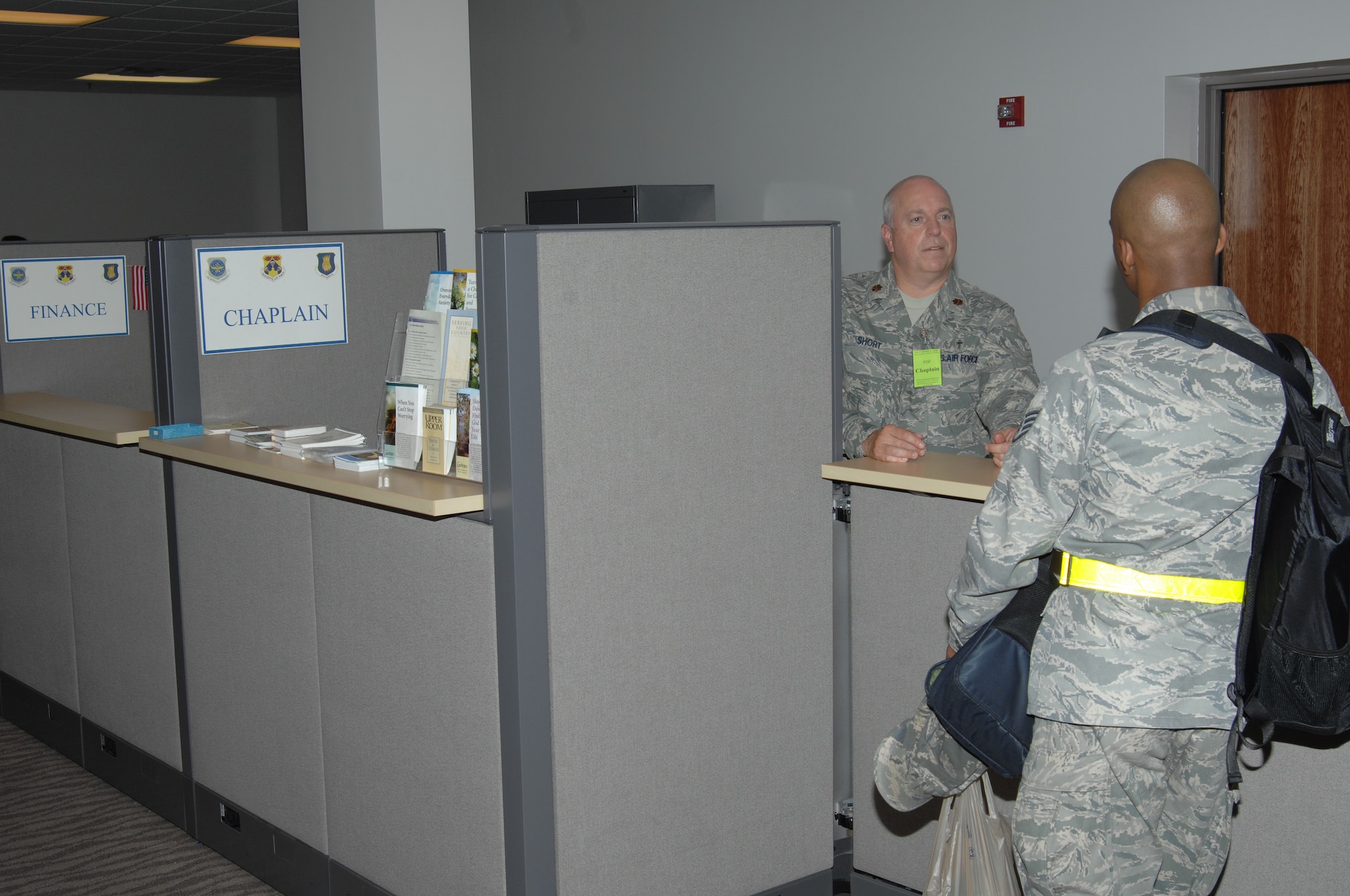 Chaplain (Maj.) Boyd Short, 22nd Air Refueling Wing Chapel, speaks with Staff Sgt. Sidney Okagu, 22nd Air Refueling Wing Command Post comptroller, while processing through the personnel deployment line during an exercise, Aug. 15, 2010, McConnell Air Force Base, Kan.  The deployment line gathers specialists from different organizations around base to a central location and provides every deploying member with individual assistance ensuring all their affairs are in order prior to deployment.  (U.S. Air Force photo/Staff Sgt. Ronald Lafosse)