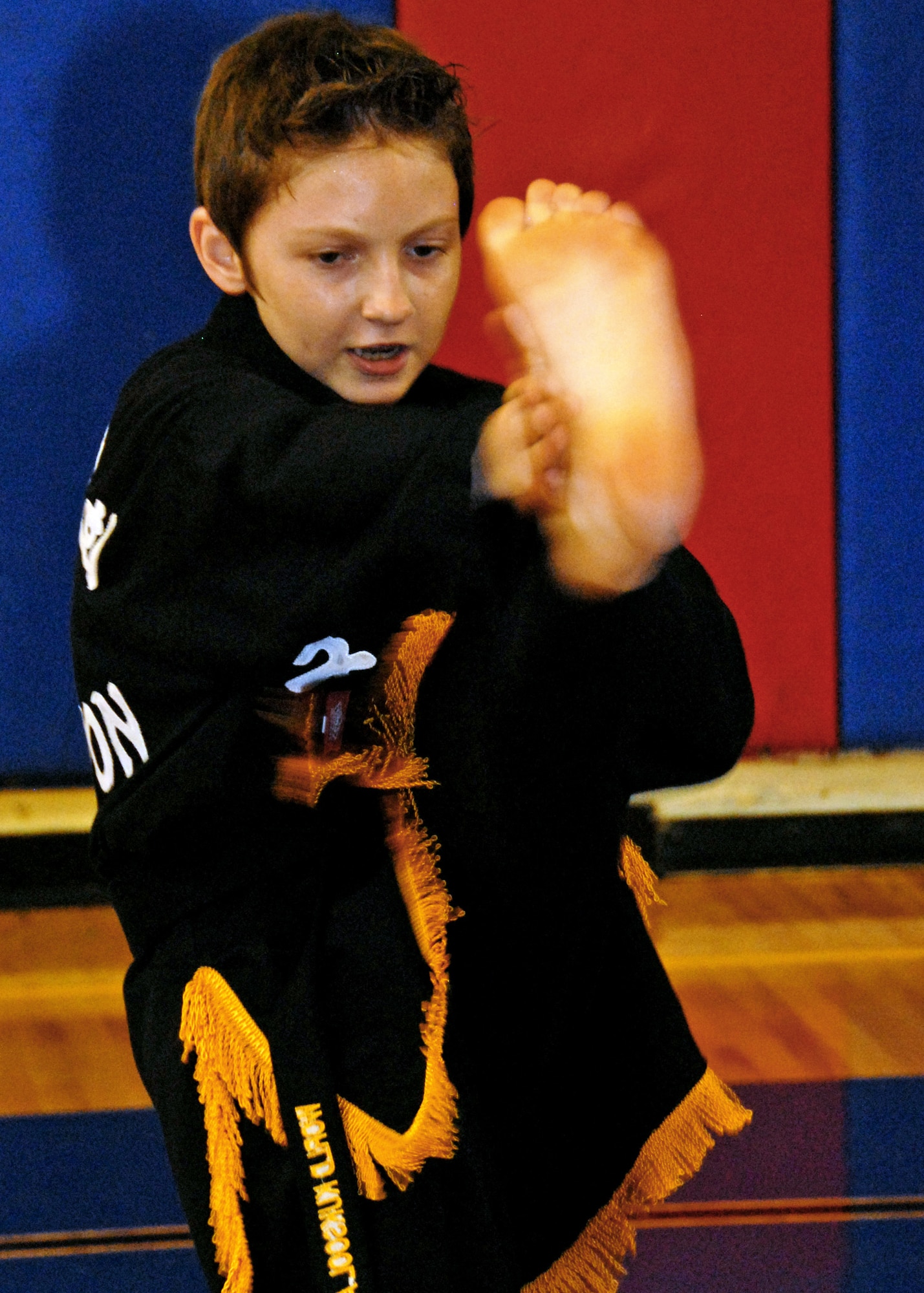 Ryan Schweitzer, brings his kick up to meet his hand during Kuk Sool Won class at Eglin Air Force Base, Fla.  Schweitzer, son of Master Sgt. Kevin Schweitzer, 1st Special Operations Maintenance Squadron, earned his black belt in June.  The 12-year-old has been training for four years.  Kuk Sool Won encompasses many different "styles" of traditional martial arts.  It combines kicking, punching, throwing, falling, and joint-locking as well as a myriad of weapons techniques into a dynamic 'hard-soft' style, emphasizing speed and fluidity.  (U.S. Air Force photo by Samuel King Jr.)