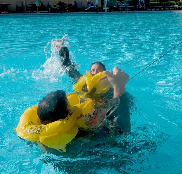 Maj. Mike Cranston signals for helicopter "pick up" as he participates in water survival refresher training Aug. 6, 2010, at Randolph Air Force Base, Texas. Major Cranston is a T-1 instructor pilot.  (U.S. Air Force photo/Steve White)  