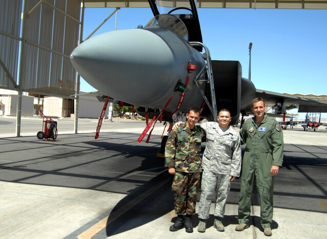 NELLIS AIR FORCE BASE, Nev.-- Staff Sgt. James and Tech. Sgt. David Goodnight stand with Maj. Gen. Ted Kresge, U.S. Air Force Warfare Center commander, on the Nellis flightline after a joint reenlistment ceremony Aug. 13. The brothers, natives of Riverside, Calif., reenlisted together because they are stationed close to each other and they thought it would be a unique thing to do as third generation Airmen. James enlisted in the Air Force in 2002, and is a dedicated crew chief with the 757th Aircraft Maintenance Squadron, Eagle Aircraft Maintenance Unit at Nellis. David enlisted in 1998, and is a communications systems shift supervisor with the 432nd AMXS at Creech Air Force Base, Nev. (U.S. Air Force photo by Caitlin Fairchild)