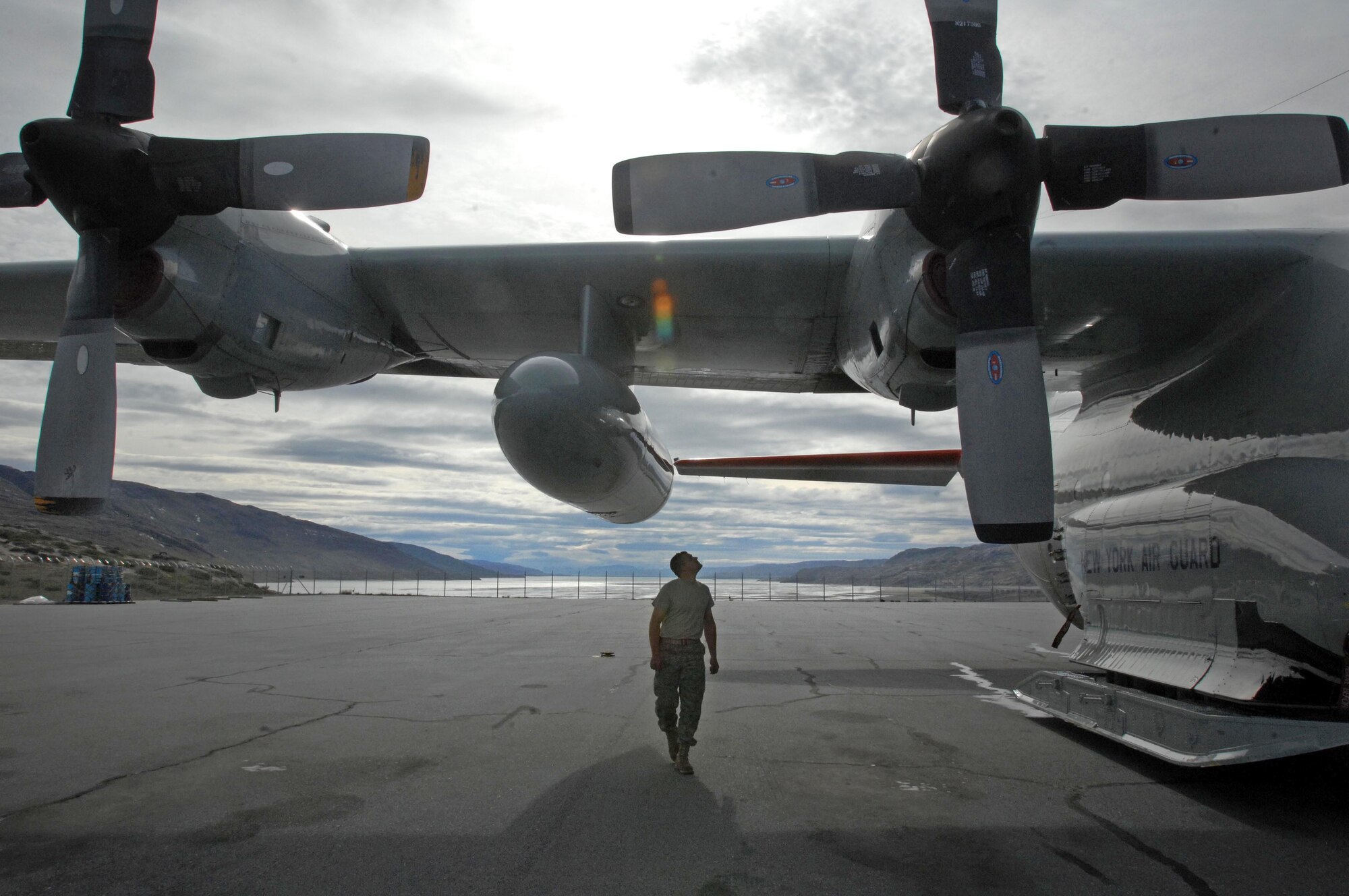 Staff Sgt. Kevin Byrns walks around the ski-equipped LC-130 Hercules cargo planes, following a mission July 29, 2010, to one of the remote science outposts in Greenland. Sergeant Burns is the crew chief for the 109th Airlift Wing of the New York Air National Guard. (Department of Defense photo/Fred W. Baker III)