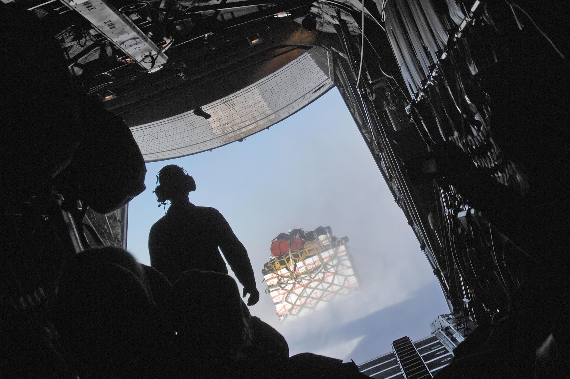 A crew chief watches as supplies slide off of the LC-130 Hercules cargo plane and onto the ice sheet July 28, 2010, at a remote science research site in Greenland. The 109th Airlift Wing is the only military unit in the world to fly such aircraft and has flown missions to Greenland since 1975. The unit now provides airlift support to the National Science Foundation's polar research program here. (Department of Defense photo/Fred W. Baker III)