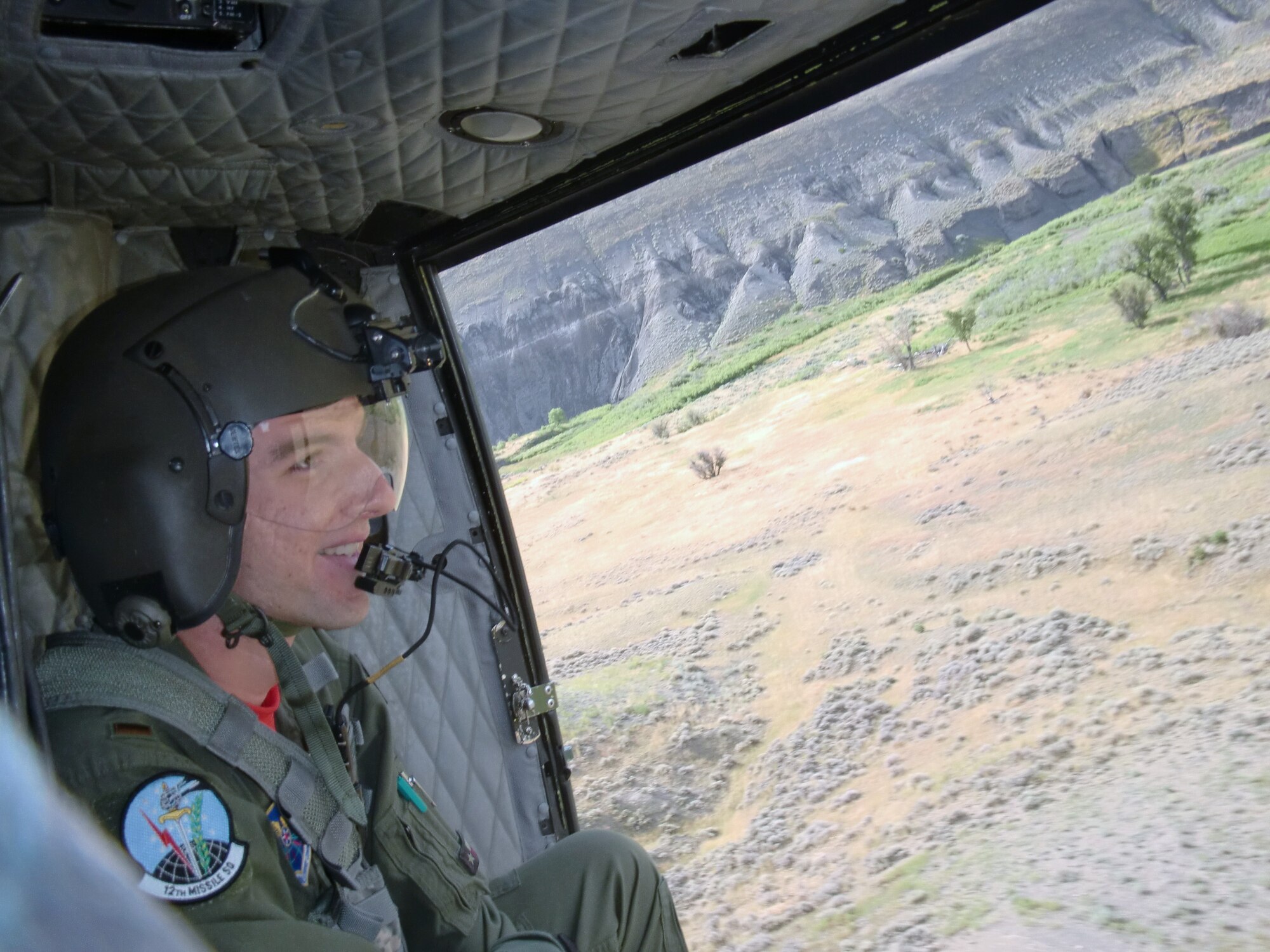 2nd Lt. Nolan Vaughan, 12th MS ICBM combat crew deputy commander, gazes out at the landscape during a Helicopter flight for the Ops Warrior competition Aug. 5. His normal duty location is 60 feet below the ground in a missile alert facility, so flying a few hundred feet in the air with the 40th Helicopter Squadron to do hoist competitions is a new experience. (courtesy photo)
