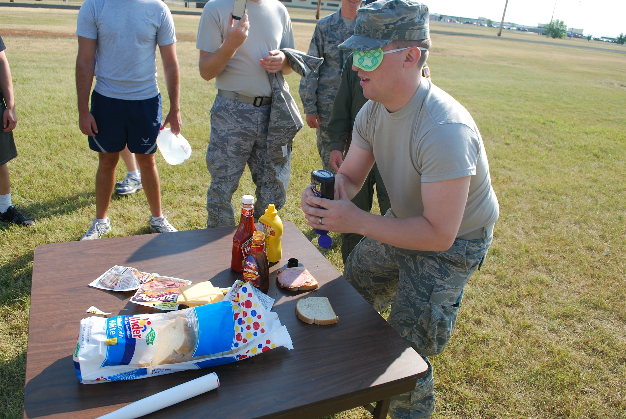Airman 1st Class Robert Swinehart, 490th Missile Squadron chef, finishes the second to last part of the Ops Warrior challenge course by making a sandwich blindfolded for a facility manager to eat for the competition Aug. 5. The challenge course presented different tasks to represent each part of the various squadrons to include missile chefs, facility managers and missileers.  (U.S Air Force photo/Airman 1st Class Kristina Overton)