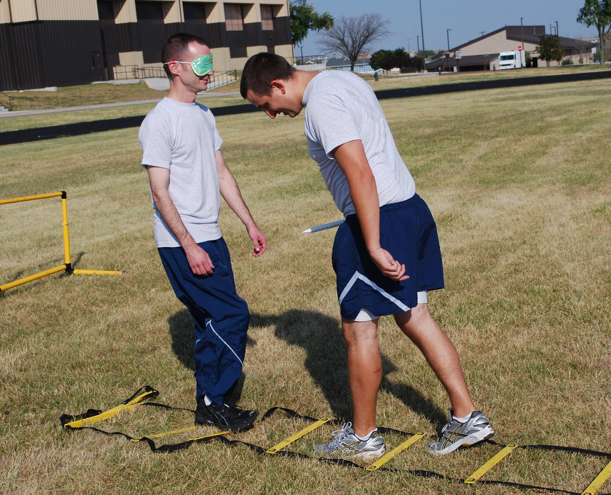 First Lt. Griff Hofman, 490th Missile Squadron missileer, leads aa blindfolded1st Lt. Brian Contival, 490th MS combat crew commander, through the obstacle course blindfolded for the Ops Warrior Competition Aug. 5. (U.S Air Force photo/Airman 1st Class Kristina Overton)