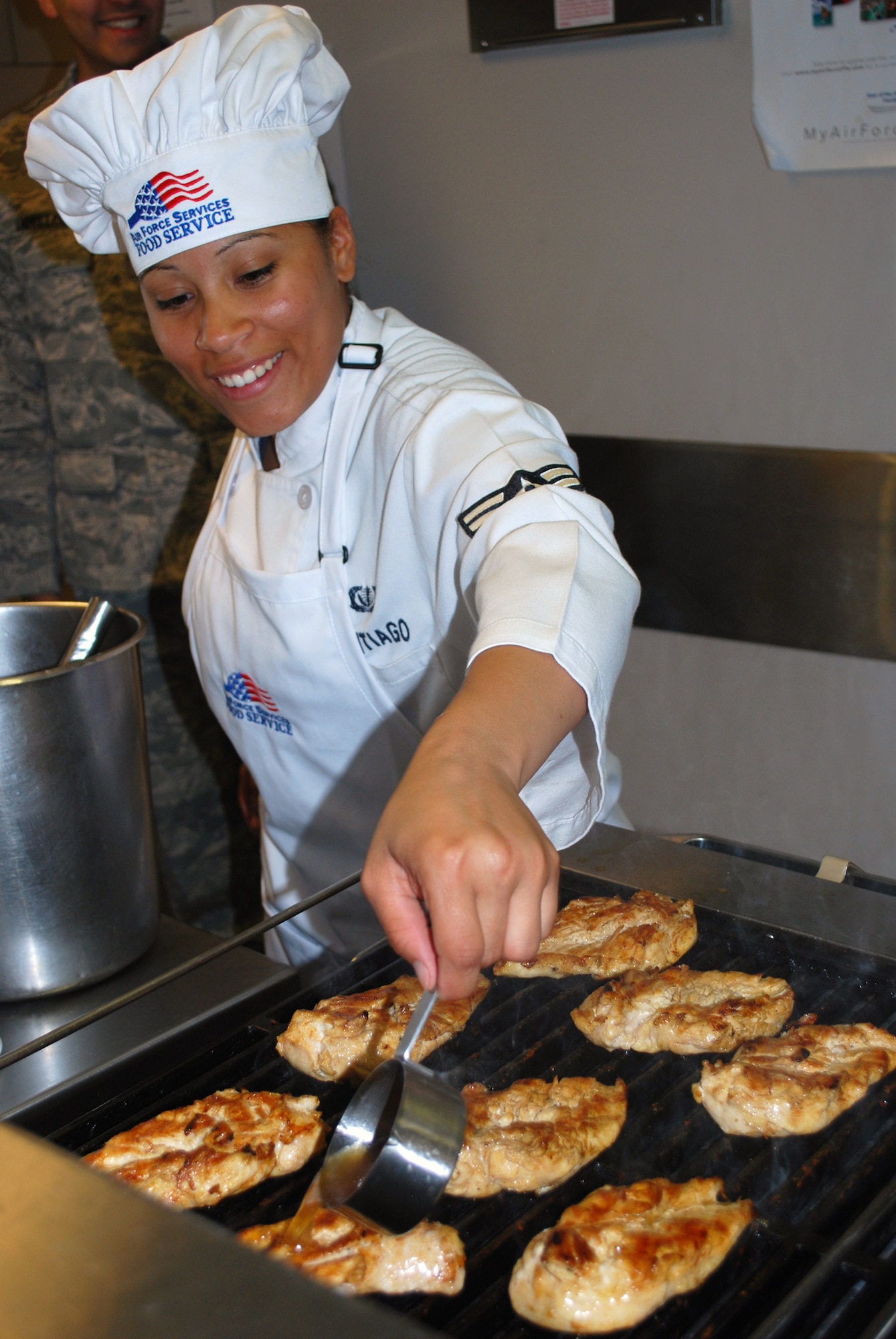 Airman 1st Class Miriam Santiago, 10th Missile Squadron chef, pours some tangerine-maple glaze onto some chicken breasts in preparation of her team’s signature dish at the Warrior Chef competition Aug. 5. The common ingredient used in the competition was maple syrup. (U.S Air Force photo/Airman 1st Class Kristina Overton)