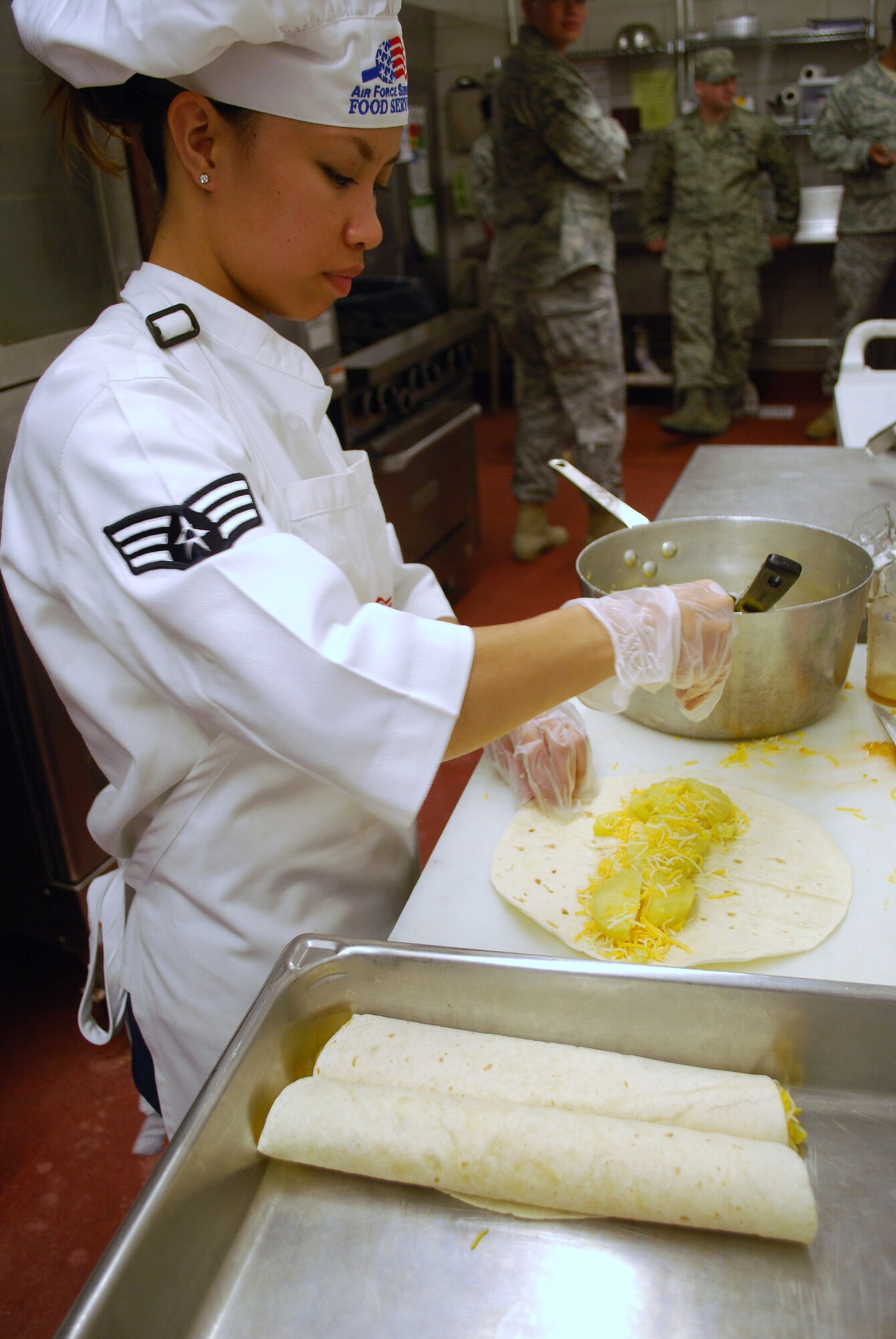 Senior Airman Aimina Acosta, 10th Missile Squadron chef, sprinkles cheese on their “Grilled Sweet Potato Tacos” during the Warrior Chef competition at the Elkhorn Dining Facility Aug. 5. (U.S Air Force photo/Airman 1st Class Kristina Overton)