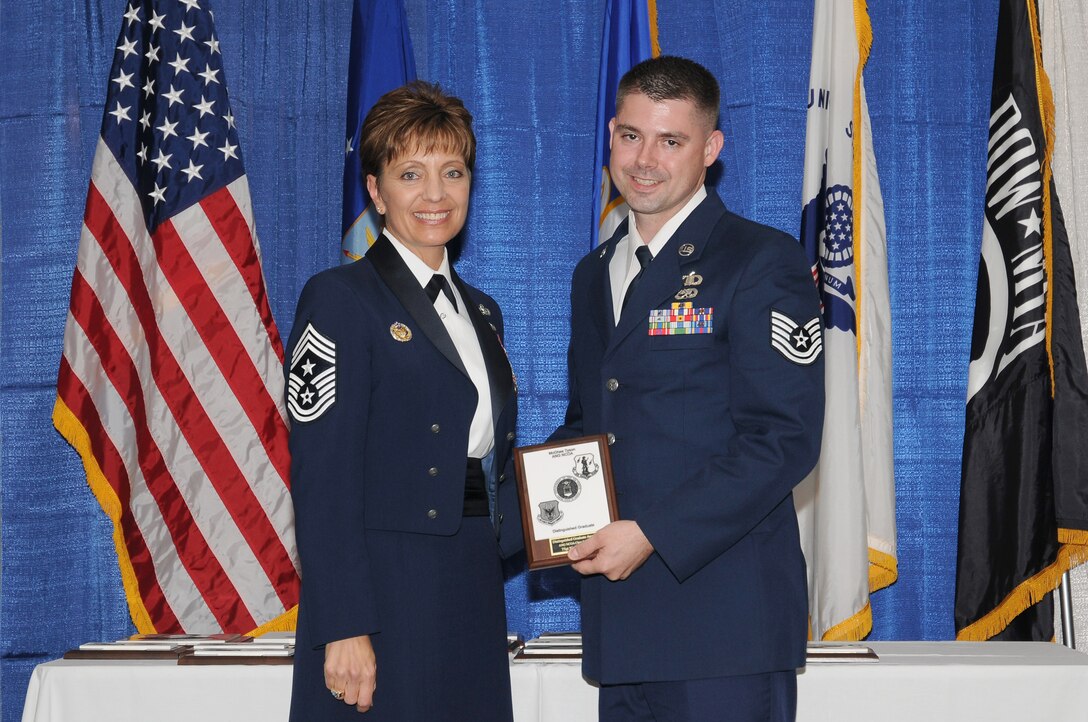 McGHEE TYSON AIR NATIONAL GUARD BASE, Tenn. -- Tech. Sgt. Nicky S. Jolly, right, receives the distinguished graduate award for NCO Academy Class 10-7 at The I.G. Brown Air National Guard Training and Education Center here from Chief Master Sgt. Denise Jelinski-Hall, Aug. 12, 2010.  The distinguished graduate award is presented to students in the top ten percent of the class.  It is based on objective and performance evaluations, demonstrated leadership, and performance as a team player. (U.S. Air Force photo by Master Sgt. Kurt Skoglund/Released)