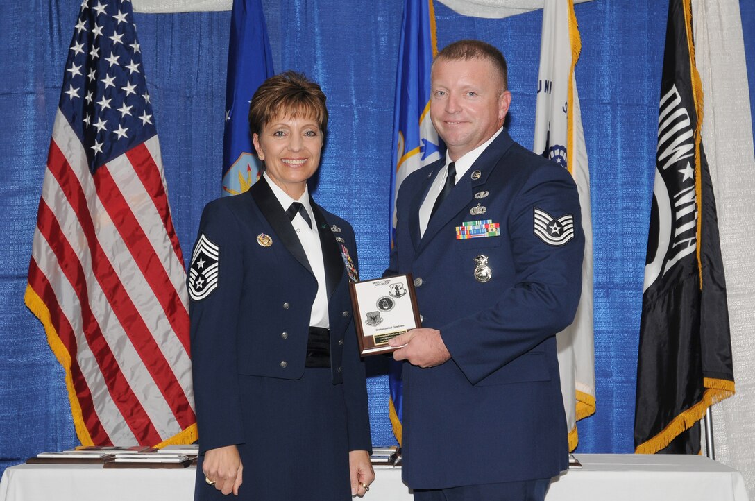 McGHEE TYSON AIR NATIONAL GUARD BASE, Tenn. -- Tech. Sgt. Michael W. Parson, right, receives the distinguished graduate award for NCO Academy Class 10-7 at The I.G. Brown Air National Guard Training and Education Center here from Chief Master Sgt. Denise Jelinski-Hall, Aug. 12, 2010.  The distinguished graduate award is presented to students in the top ten percent of the class.  It is based on objective and performance evaluations, demonstrated leadership, and performance as a team player. (U.S. Air Force photo by Master Sgt. Kurt Skoglund/Released)