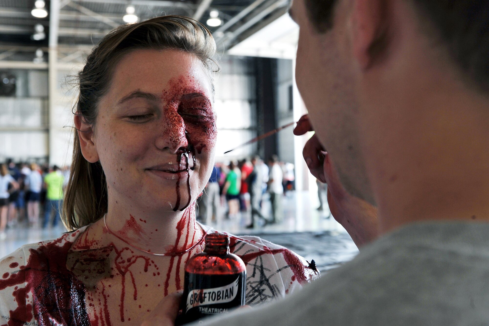 OFFUTT AIR FORCE BASE, Neb. - Airman 1st Class Cassandra Miller, 55th Operations Group, receives a faux facial injury from Airman 1st Class David Jones, 55th Dental Squadron, during a major accident response exercise August 14. Airmen with the 55th Medical Group worked with medical professionals from the surrounding Omaha metro area take part in this annual exercise that simulates an aircraft accident in preperation for the Defenders of Freedom Open House and Air Show hosted here. U.S. Air Force photo by Charles Haymond