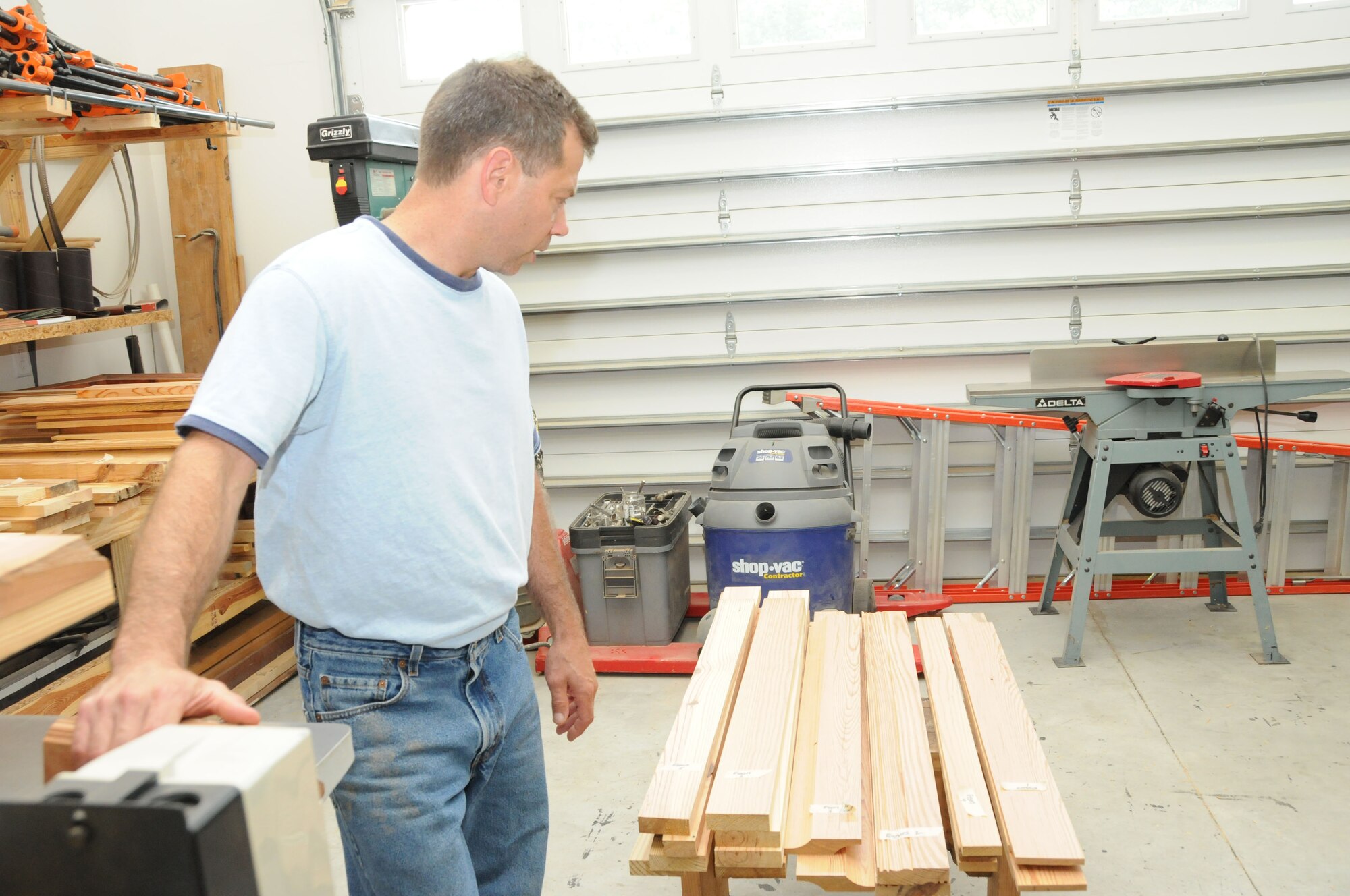 Sergeant Gary Tumminia examines a load of wood to determine how he will best use it for an upcoming project. (USAF photo by SSgt. Terrica Jones, 916PA)