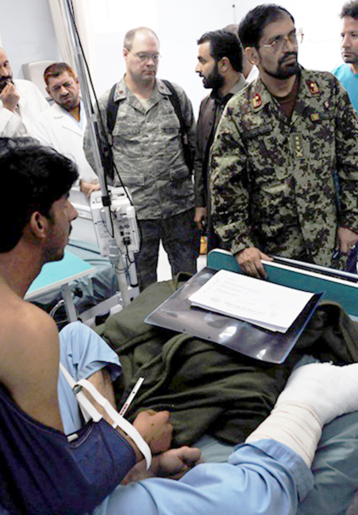 Maj. (Dr.) Robert Sarlay Jr. observes as Afghan army physicians conduct patient rounds Aug. 15, 2010, at the Paktia Regional Medical Hospital, Afghanistan. Major Sarlay is a mentor for the medical embedded training team at Forward Operating Base Lightning, Afghanistan. (U.S. Army photo/Sgt. Spencer Case)
