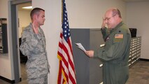 Senior Airman Fink, 916th Aircrew Flight Equipment shop, re-enlists for six years as Lt. Col. Mark Sigler, Operations Support Squadron commander, issues the oath of enlistment. (USAF photo by TSgt. Ian Gardner, 916OSS).  