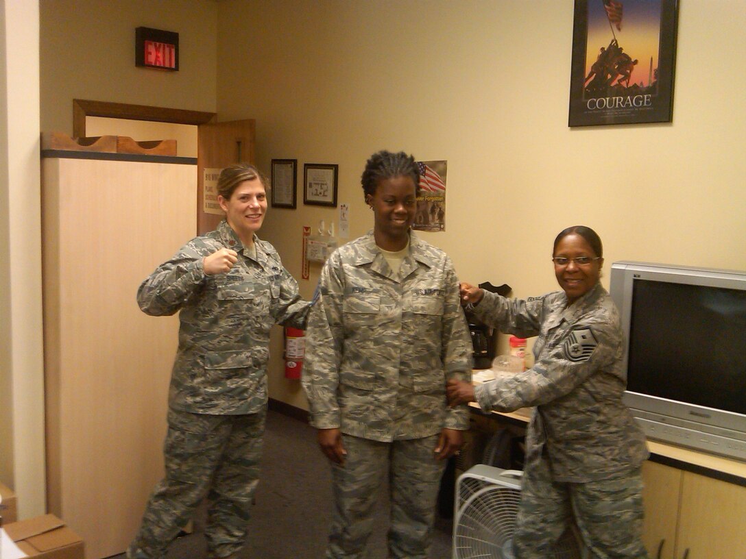 Tech. Sgt. Denise Kemp-Jackson (center), 916th Maintenance Operations Flight, is promoted by Maj.  Amanda Sheets, commander, and Master Sgt. Carla Sanders, first sergeant. Sergeant Kemp is a production scheduler. (USAF photo courtesy of 916MOF)