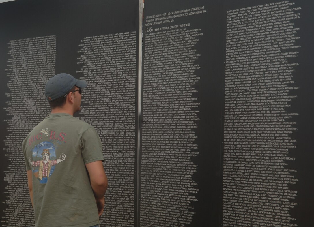 ELLSWORTH AIR FORCE, S.D. – Airman 1st Class John Weaver, 28th Maintenance Squadron aircraft fuel systems maintainer, pauses for a moment to read some of the names on the traveling wall in the Buffalo Chip, Sturgis, S.D., Aug. 8.  The traveling wall contains all of the names on the original Vietnam Memorial Wall. (U.S. Air Force photo/Airman 1st Class Alessandra N. Hurley)