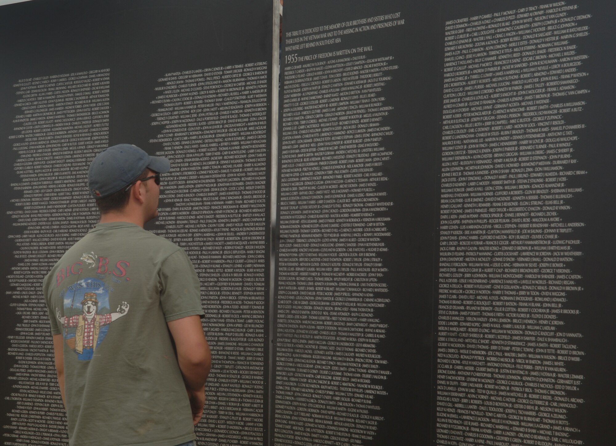 ELLSWORTH AIR FORCE, S.D. – Airman 1st Class John Weaver, 28th Maintenance Squadron aircraft fuel systems maintainer, pauses for a moment to read some of the names on the traveling wall in the Buffalo Chip, Sturgis, S.D., Aug. 8.  The traveling wall contains all of the names on the original Vietnam Memorial Wall. (U.S. Air Force photo/Airman 1st Class Alessandra N. Hurley)