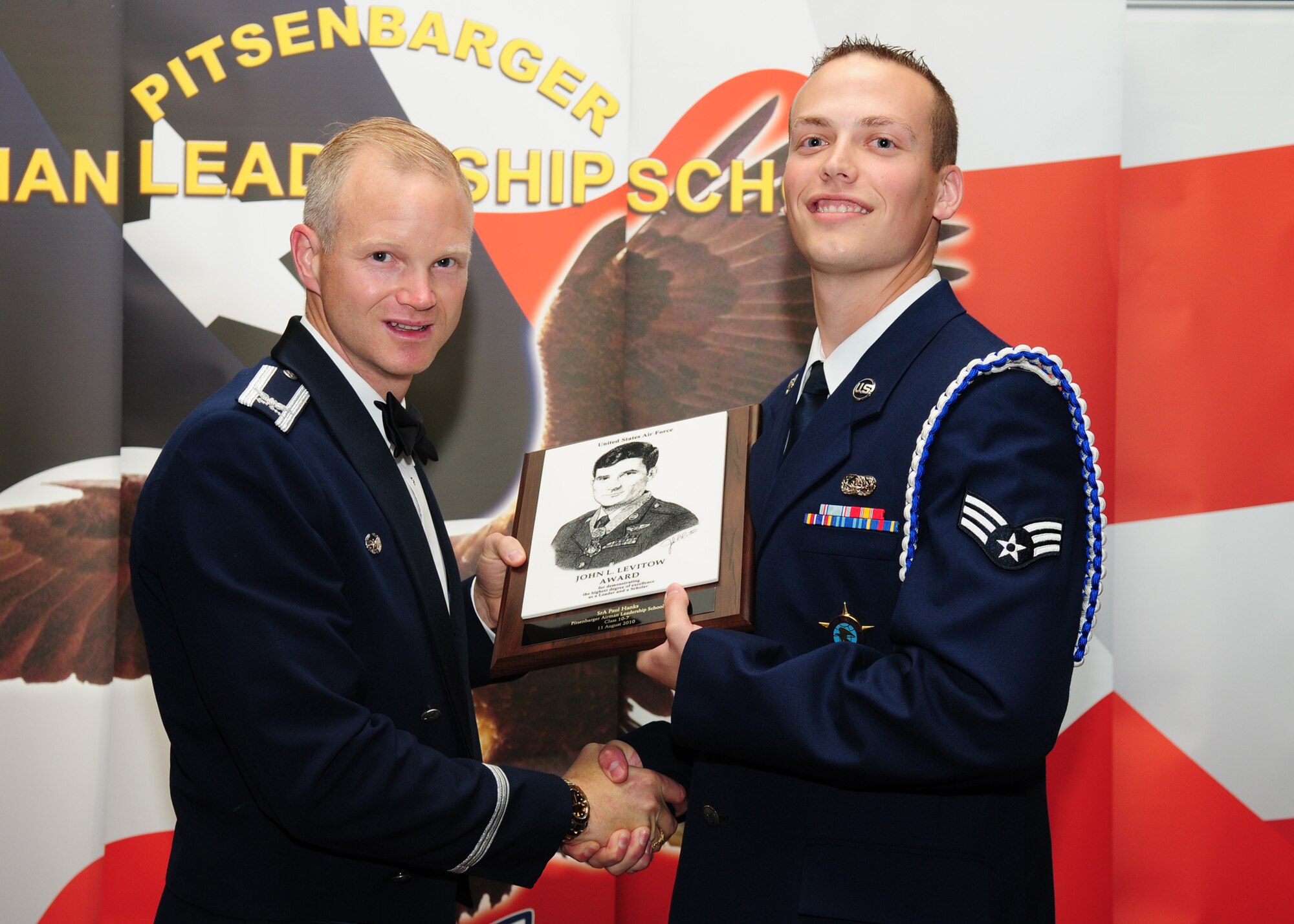 SPANGDAHLEM AIR BASE, Germany -- Senior Airman Paul Hanks, 52nd Communications Squadron, receives the John L. Levitow Award from Col. Christopher Weggeman, 52nd Fighter Wing commander, during the Pitsenbarger Airman Leadership School Class 10-7 graduation in Club Eifel Aug. 11. The John L. Levitow award is the highest award an Airman can receive upon completion of ALS. (U.S. Air Force photo/Staff Sgt. Heather M. Norris)