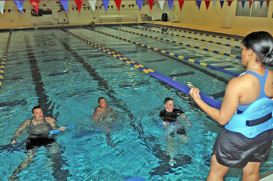 Staff Sgt. Tiara Warrick, Fort Eustis Warrior Transition Unit cadre member, leads (from left) Spc. Robert Moore, Sgt. Jason Johnson and Spc. Eric Jacques, all of the Eustis WTU, in bicep curls during a session of aquatic exercises August 10 at the Fort Eustis Aquatic Center. (Photo by Lyna Tucker)
