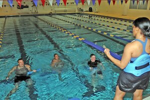 Staff Sgt. Tiara Warrick, Fort Eustis Warrior Transition Unit cadre member, leads (from left) Spc. Robert Moore, Sgt. Jason Johnson and Spc. Eric Jacques, all of the Eustis WTU, in bicep curls during a session of aquatic exercises August 10 at the Fort Eustis Aquatic Center. (Photo by Lyna Tucker)
