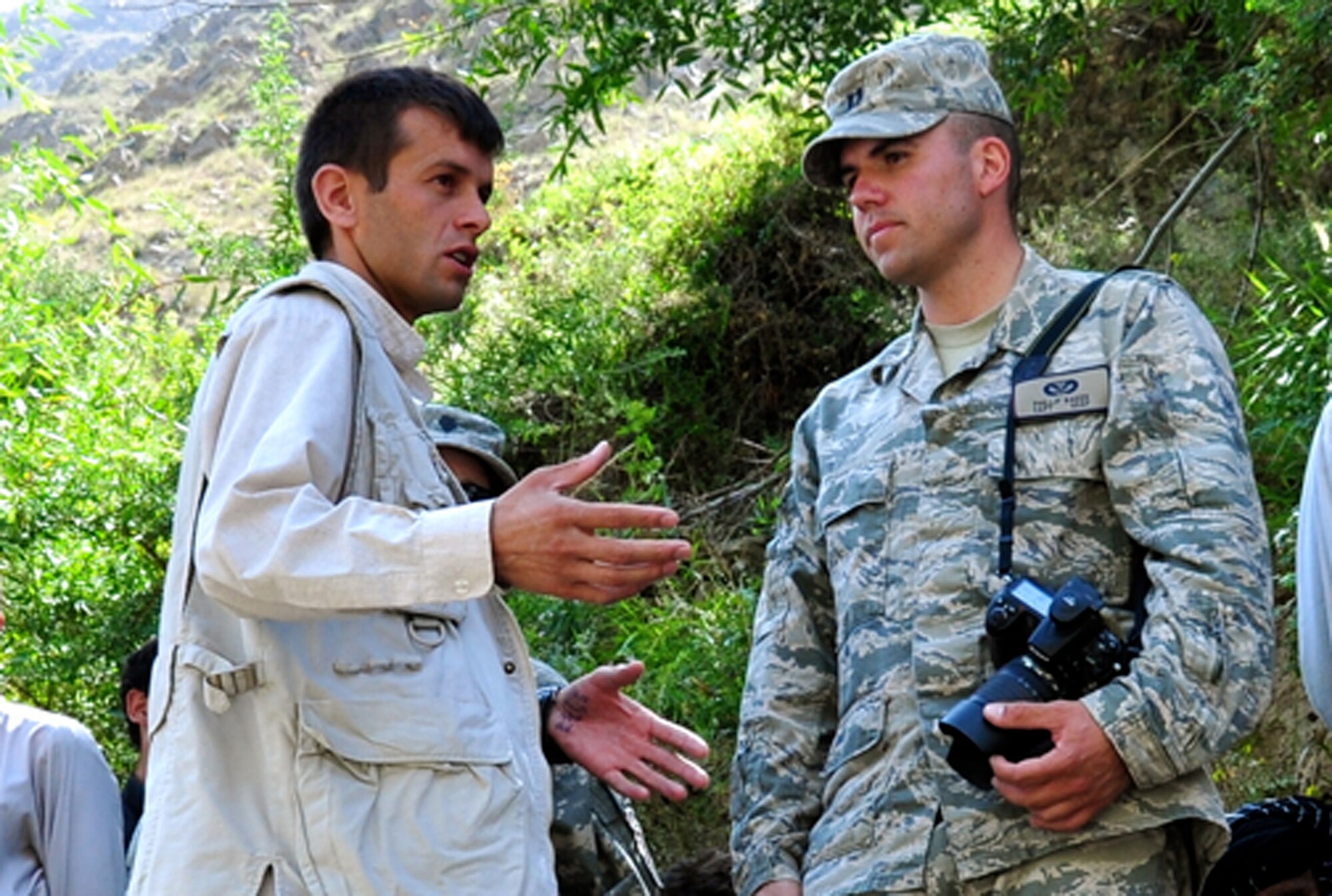 U.S. Air Force Capt. Phillip Baker, Provincial Reconstruction Team Panjshir civil engineer and San Antonio native, speaks with Ghulm Azrat from Ghulam Nabi Yaqoobi Construction and Road Construction Company regarding road construction. Heavy rain washed away a major travel route for three villages in the Dara District in early August. The Afghan National Police, local government and PRT Panjshir are teaming up on the cleanup effort. (Photo by U.S. Air Force 1st Lt. Holly Hess, PRT Panjshir Public Affairs)