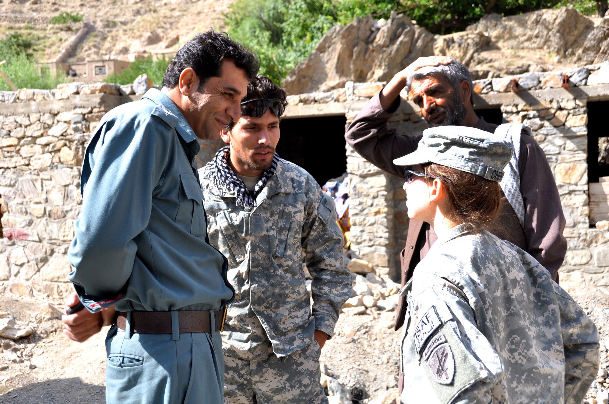 Dara Afghan National Police Col. Del Agha speaks with U.S. Army Spc. Allison Cherkosly, a Clifton Park, N.Y., native and Provincial Reconstruction Team Panjshir civil affairs member, regarding the logistics of delivering humanitarian assistance to the Abdullah Khel Valley. Heavy rain washed away a major travel route for three villages in the Dara District in early August. The Afghan National Police, local government and PRT Panjshir are teaming up on the cleanup effort. (Photo by U.S. Air Force 1st Lt. Holly Hess, PRT Panjshir Public Affairs)