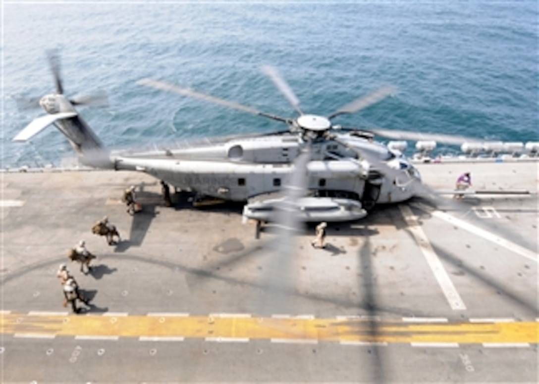 U.S. Marines board an MH-53E Sea Dragon helicopter assigned to Helicopter Mine Countermeasure Squadron 15 aboard the USS Peleliu (LHA 5) while underway in the North Arabian Sea on Aug. 12, 2010.  The Peleliu Amphibious Ready Group is preparing to support the Pakistani government and military disaster relief efforts with heavy lift capabilities in flooded regions of Pakistan.  