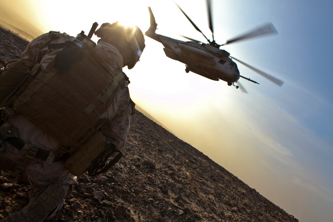 Staff Sgt. Rey Castro, the staff non-commissioned officer in charge of the 1st Marine Division's Personal Security Detachment, ducks his head to avoid rotor wash as a CH-53E Super Stallion from Marine Heavy Helicopter 361, 3rd Marine Aircraft Wing (Forward), flies away after inserting Marines and geologists at helicopter landing zone Barton, Khan Neshin Ghar, Afghanistan, in support of Operation Centrum, Aug. 16.  The squadron used two Super Stallions to transport the 17-man security detachment and six geologists into the area in search of rare valuable earth elements, which are used to polish glass, build high-end electronics and construct light-weight metals that can withstand high heat.