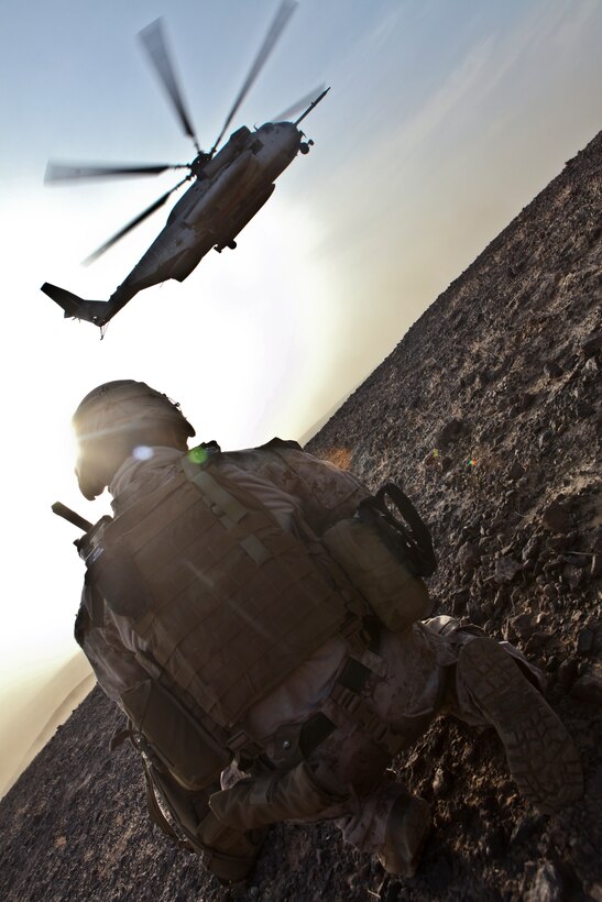 Capt. Brian O'Shea, the officer in charge of the 1st Marine Division (Forward)'s Personal Security Detachment, provides overwatch for his Marines and a team of geologists Aug. 16 while on a patrol in support of Operation Centrum. Two CH-53E Super Stallion helicopters from Marine Heavy Helicopter Squadron 361, 3rd Marine Aircraft Wing (Fwd), inserted the Marines and geologists into the remote area, allowing the geologists to extract almost 200 pounds of samples for further testing. The steep ravines and broken ground make the area inaccessible by vehicle.