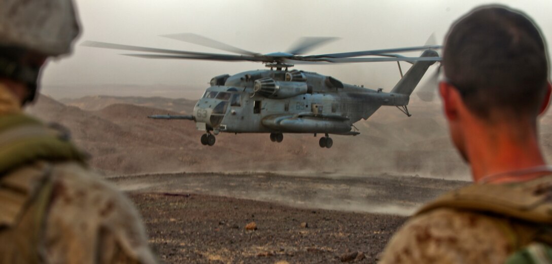 Marines with the 1st Marine Division (Forward)'s Personal Security Detachment watch a CH-53E Super Stallion from Marine Heavy Helicopter Squadron 361, 3rd Marine Aircraft Wing (Fwd), land at helicopter landing zone Barton Aug. 16 in support of Operation Centrum. HMH-361 inserted and extracted 16 Marines, a Navy corpsman and six geologists from the area. Having 3rd MAW (Fwd)’s support allowed the team to extract almost 200 pounds of samples for further testing.