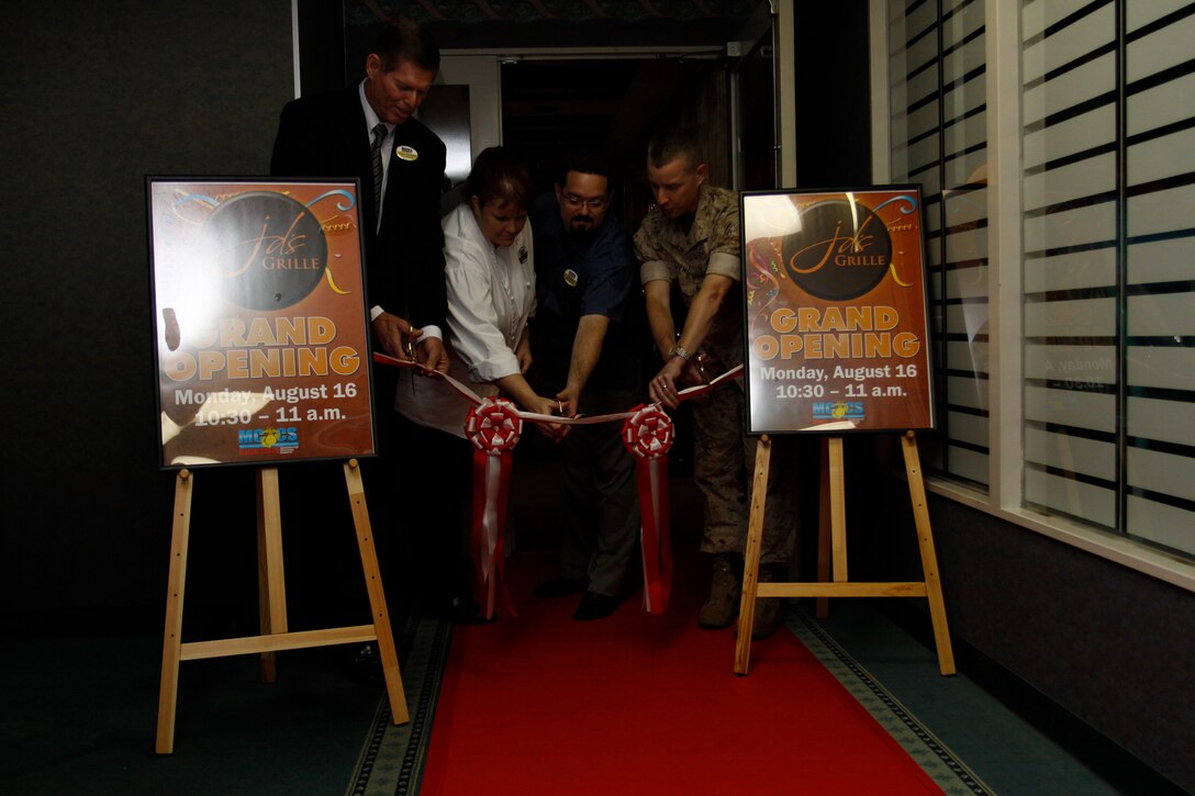 John Iwaniec, Marine Corps Community Services director; Ginna Benke, JD’s Grille executive chef; Christopher Braswell, JD’s Grille club manager; and Col. James C. Stewart, station commanding officer, cut a ribbon to officially open JD’s Grille here for business during a ceremony Aug. 16. JD’s Grille is named for Cpl. Jason Dunham, the first Marine to receive a Medal of Honor during Operation Iraqi Freedom and Operation Enduring Freedom. The restaurant menu features many of the same specials as the old grill with a few additions, including steaks and pastas.