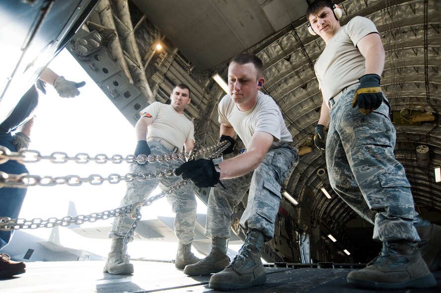 Senior Airman Adam Mertz, 721st Aerial Port Squadron, Ramstein Air Base, Germany, secures cargo on board a C-17 Globemaster III while undergoing Aerial Port Expeditor training Aug. 17, 2010, at Joint Base Lewis-McChord, Wash. (U.S. Air Force Photo/Abner Guzman) 