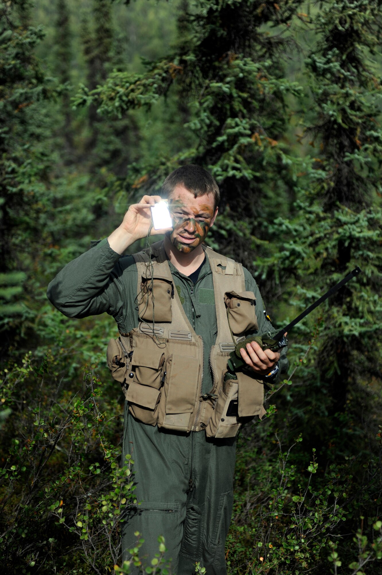 A simulated downed pilot uses a signal mirror to signal his location to rescue forces August 11, 2010, Eielson Air Force Base, Alaska. The simulated downed pilot was participating in a Survival Evasion Resistance Escape training operation during Red Flag-Alaska 10-4. (U.S. Air Force photo/Senior Airman Willard E. Grande II)