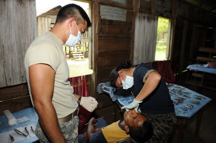 PIMIENTA, Honduras --  1st Lt. Adrian Spears, with the Medical Element at Soto Cano Air Base, and Capt. Meylan Monterroso, a Honduran Army dentist, conduct an extraction on a patient here Aug. 10. The dental team treated 105 patients over the four-day medical civic action program in the La Moskitia province. (U.S. Air Force photo/Tech. Sgt. Benjamin Rojek)