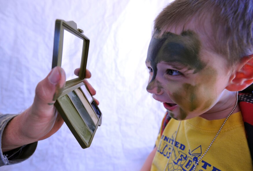 HOLLOMAN AIR FORCE BASE, N.M. -- Leo Ford, son of Master Sgt. Geoffrey Ford, 849th Aircraft Maintenance Squadron, takes a glance at his camouflage face paint during Operation K.I.D.: Kids Investigating Deployment, Aug. 12, 2010. Children had their war faces painted in a tent set up by the 49th Security Force Squadron during the event at the Basic Expeditionary Airfield Resources Base. The 49th SFS was one of eight unit displays set up for children to see and learn about. (U.S. Air Force photo by Senior Airman Veronica Stamps / Released)