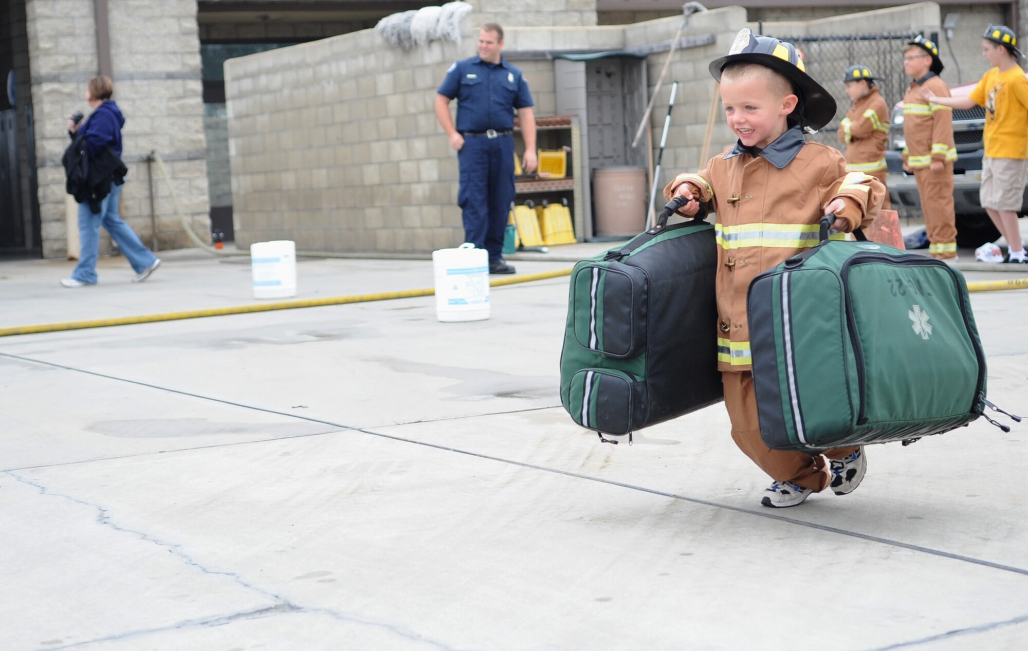 VANDENBERG AIR FORCE BASE, Calif. -- A local child here swiftly transports medical bags to a victim (simulated) during an obstacle course at the Kids Fire Camp here Saturday, Aug. 14, 2010. During the obstacle course children were given the opportunity to play the role of a firefighter. (U.S. Air Force photo/Senior Airman Ashley Reed)