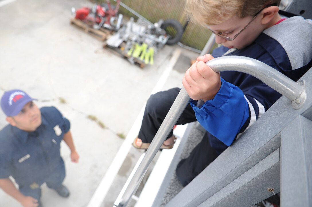 VANDENBERG AIR FORCE BASE, Calif. -- Patiently waiting, Jefferey Galvez, a 30th Civil Engineer Squadron firefighter, assists children evacuating a simulated house fire. The Kids Fire Camp is held annually to teach children the importance of fire safety. (U.S. Air Force photo/Senior Airman Ashley Reed)