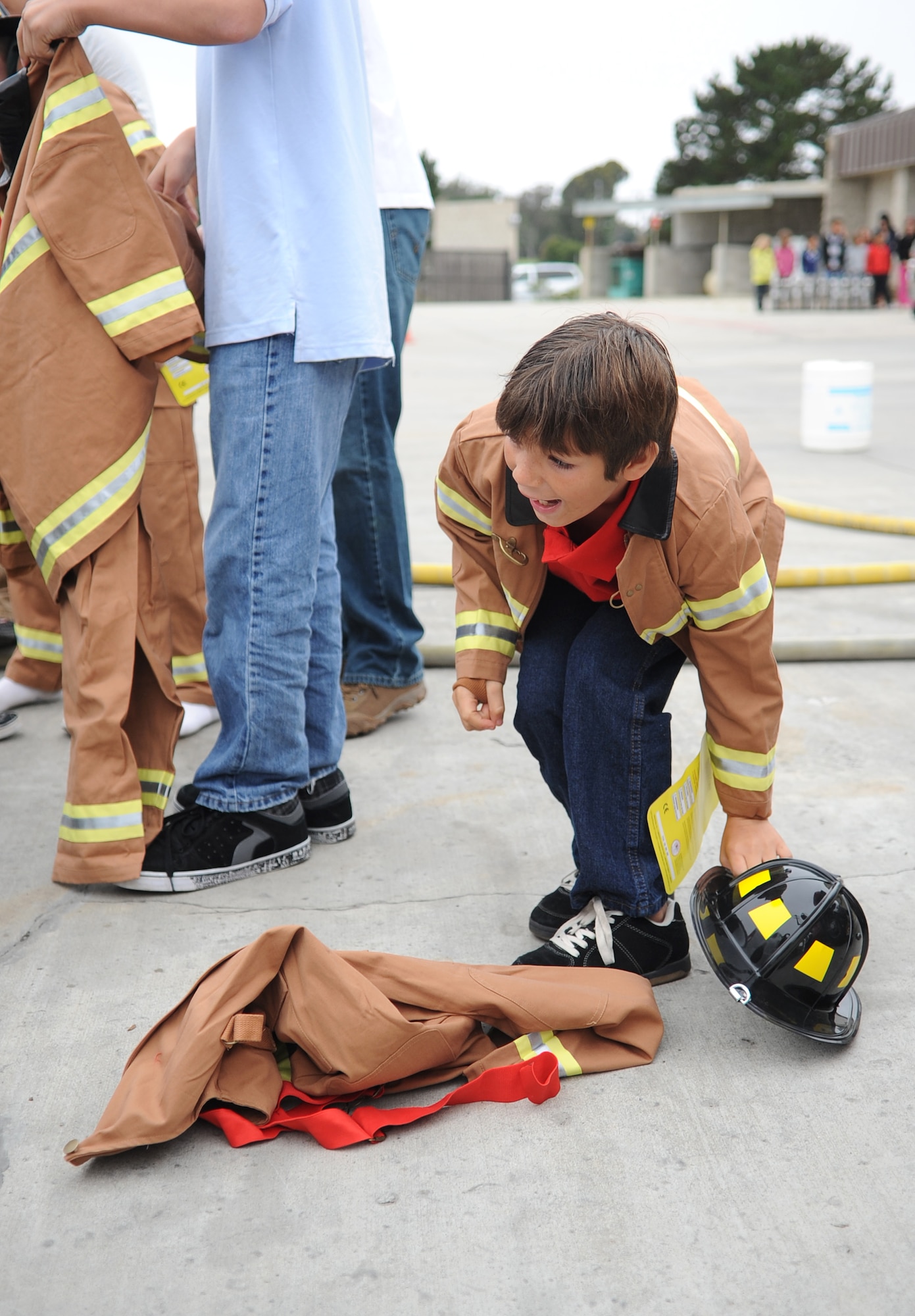 VANDENBERG AIR FORCE BASE, Calif. -- Excited to try on his new firefighter suit, a local child here gets ready for the obstacle course at the annual Kids Fire Camp here Saturday, Aug. 14, 2010. Throughout the obstacle course, children were given the opportunity to use some of the many tools used by firefighters here. (U.S. Air Force photo/Senior Airman Ashley Reed)