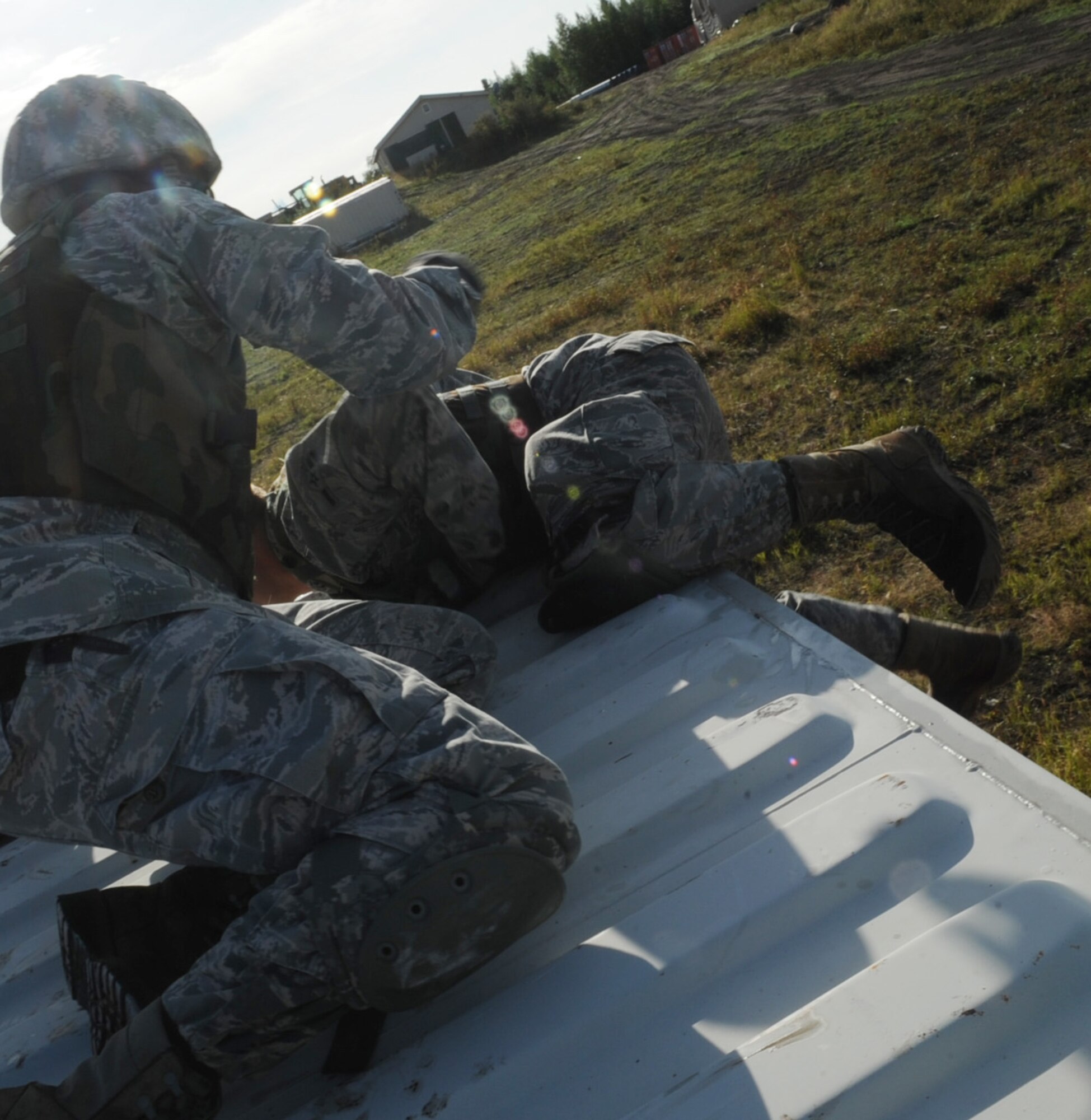 Airmen pull each other up to the top of conex boxes to idientify targets downrange to call in accurate coordinates to the aircraft during Red-Flag Alaska 10-4, August 12, 2010, Eielson Air Force Base, Alaska. The joint terminal air controllers identify ground targets for close air support missions downrange. RF-A provides oppertunities to integrate joint, coalition and bilateral training from simulated forward operating bases. (U.S. Air Force photo/Airman 1st Class Laura Goodgame)
