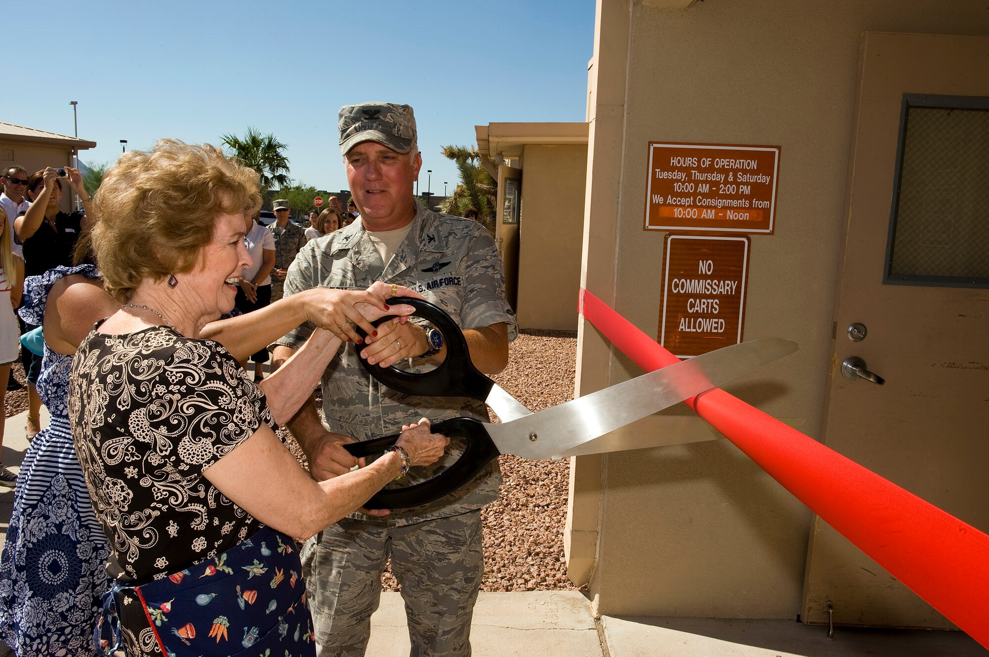 NELLIS AIR FORCE BASE, Nev.-- Hilde Jopes, a volunteer at the Nellis thrift shop, and Col. Kevin Fox, 99th Mission Support Group commander, cut the ribbon to re-open the store Aug. 17. Mrs. Jopes has been a dedicated volunteer at the thrift shop for more than 30 years and still volunteers today. The revenue from the thrift shop is donated to charities and scholarships for military personnel who are pursuing education. (U.S. Air Force Photo by Senior Airman Brett Clashman)